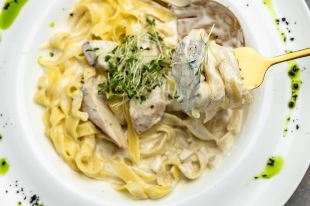 Fettuccine alfredo in een romige saus met Parmezaanse kip op wit bord Pasta alfredo met kip Italiaanse keuken banner menu recept plaats voor tekst bovenaanzicht