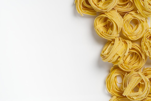 Fettuccine italian pasta isolated on white background raw tagliatelle nests isolated on white backgr...