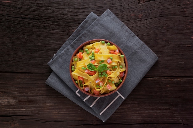 Fettuccine pasta op een houten tafel in een kom. Bovenaanzicht. Vegetarisch eten.