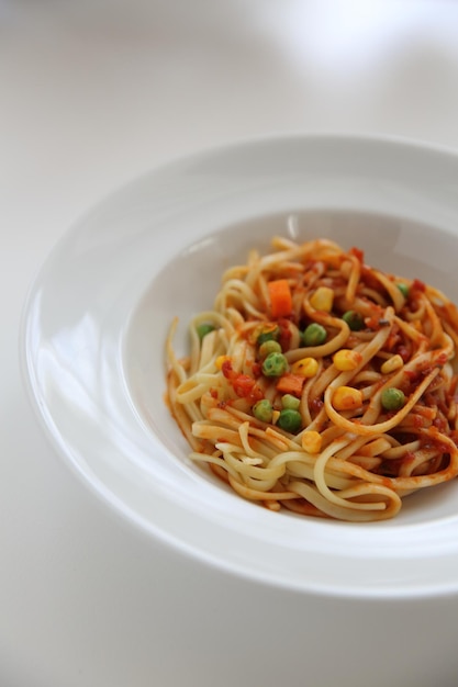 Fettuccine pasta in tomato sauce isolated in white background