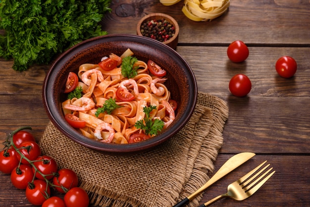 Fettuccine pasta with shrimp, cherry tomatoes, sauce, spices and herbs