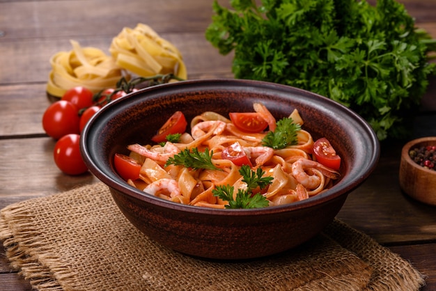 Fettuccine pasta with shrimp, cherry tomatoes, sauce, spices and herbs