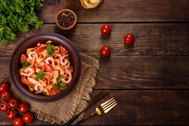 Fettuccine pasta with shrimp, cherry tomatoes, sauce, spices and herbs