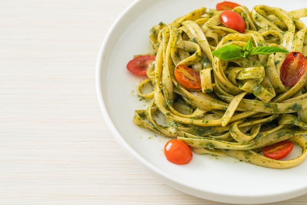 fettuccine spaghetti pasta with pesto sauce and tomatoes - vegan and vegetarian food style