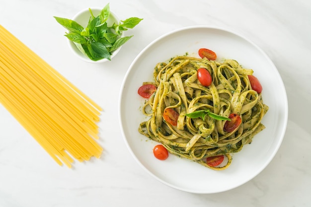 Foto fettuccine spaghetti al pesto e pomodori