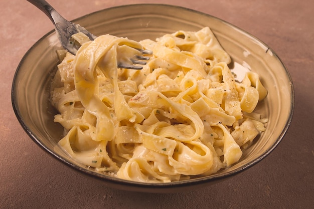 Fettuccine tagliatelle in creamy garlic sauce Italian traditional cuisine pasta carbonaro