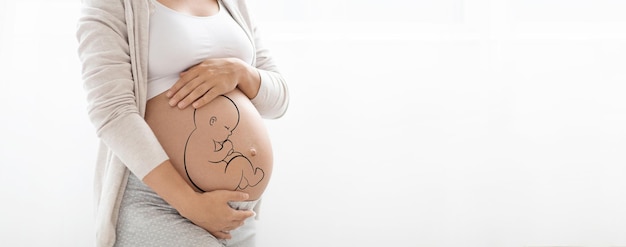 Fetus painting on big tummy of pregnant woman cropped