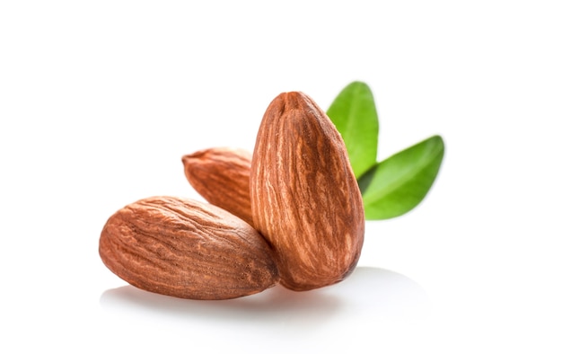 Few almond nuts with leaves isolated on white