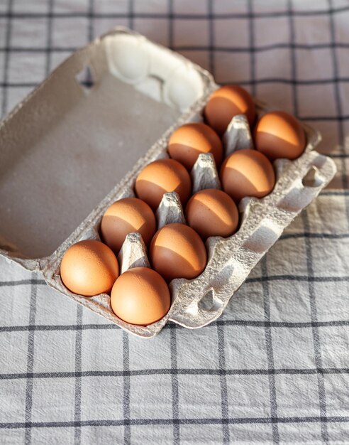 A few brown eggs among the cells of a large cardboard bag, a chicken egg as a valuable nutritious product, a tray for carrying and storing fragile eggs. A full package of eggs, an important food item