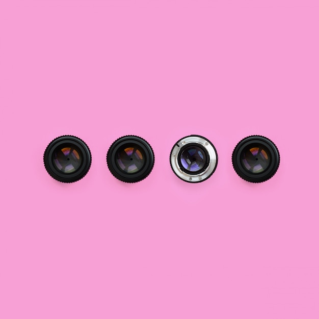 A few camera lenses with a closed aperture lie on texture background