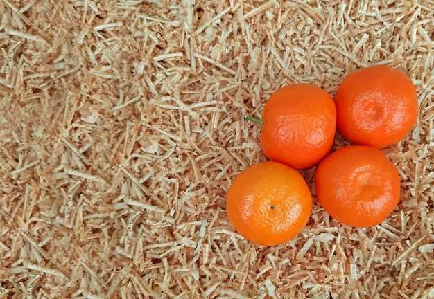 A few clementines on a background of sawdust