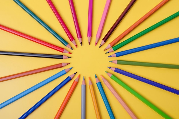 A few colored pencils on a yellowblue background Develop creativity Get creative