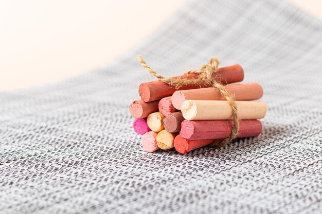 A few crayons pastels tied with a ribbon on a wicker gray napkin Pink palette