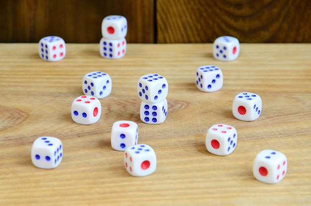 A few dice lies on the surface of natural wood. 