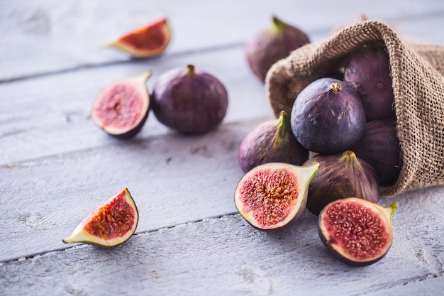 A few figs freely lying on old wooden table.