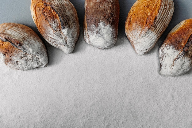 A few fresh loaves of bread with free space with flour for writing