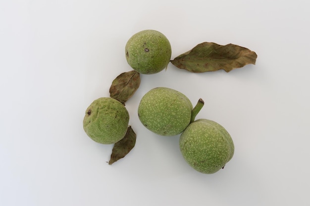 A few green walnuts on a white background