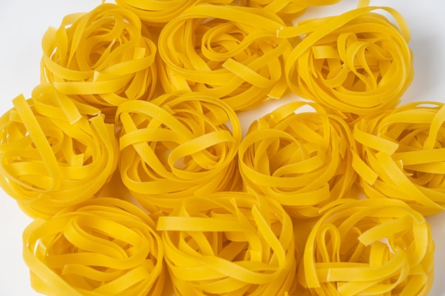 Few homemade fettuccine nest close-up isolated on white background