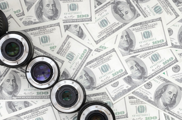 몇 장의 사진 렌즈는 많은 달러 지폐의 배경에 있습니다. 텍스트를위한 공간