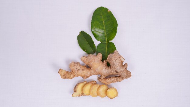 A few pieces of ginger and lime leaves isolated on white background