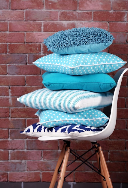 レンガ壁の背景に椅子にいくつかの枕