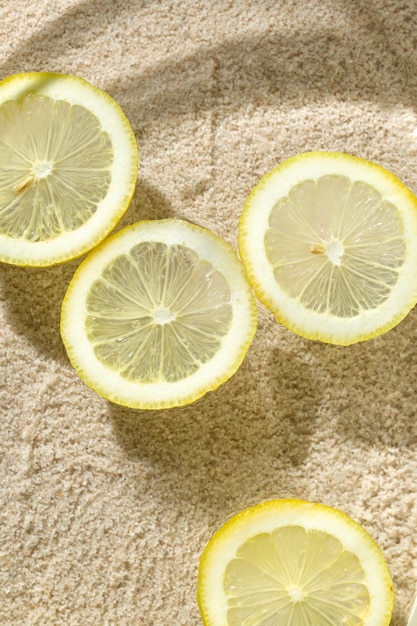 A few slices of fresh lemon floating on water sand on the background