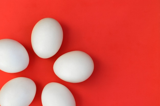 A few white eggs on a bright red background