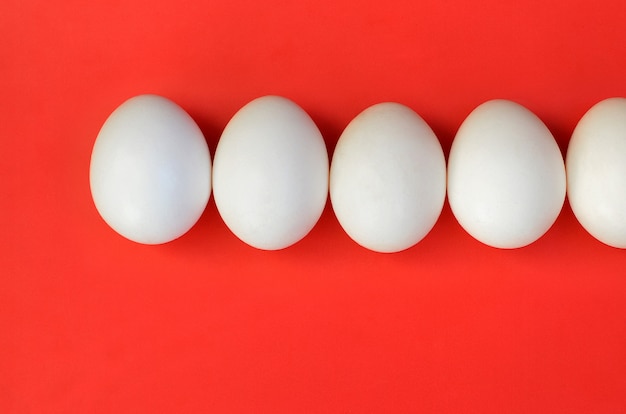 A few white eggs on a bright red background