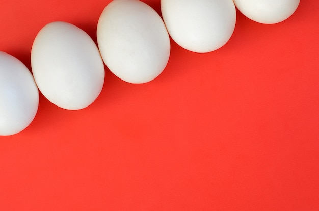 A few white eggs on a bright red background