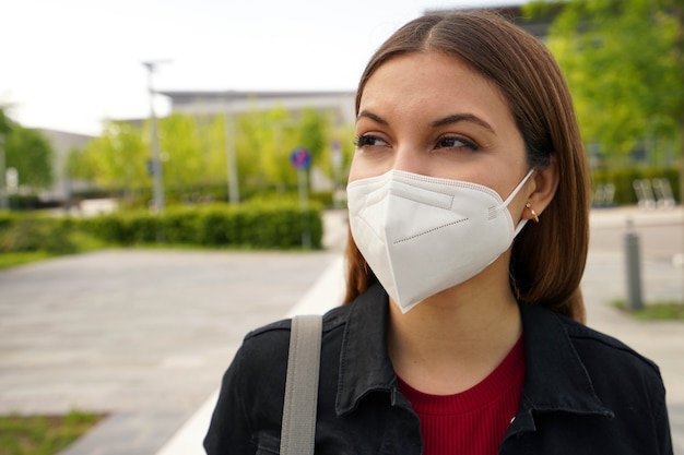 FFP2 protective mask. Close up of young woman wearing medical face mask in street as prevention and protection.