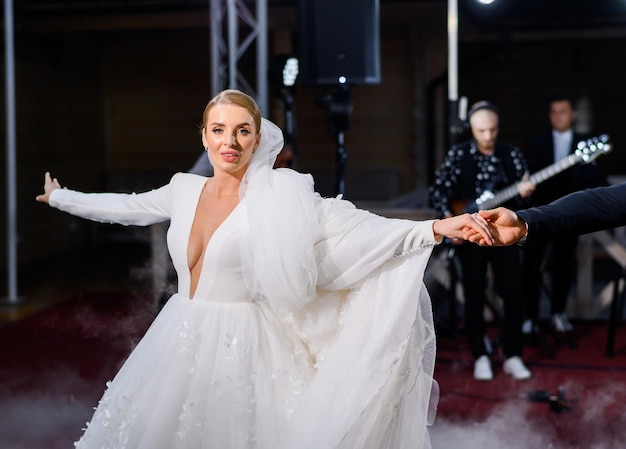 Fiancee in puffy gown dancing indoors