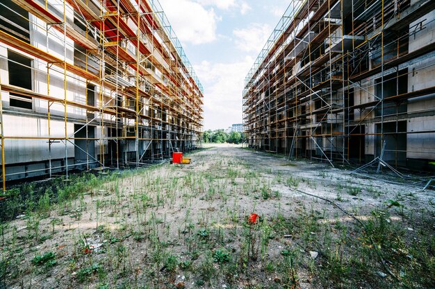 Photo field amidst buildings with scaffolding