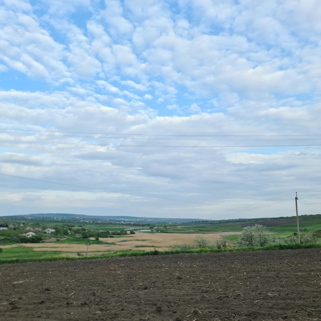 Foto un campo con un cielo azzurro e poche nuvole