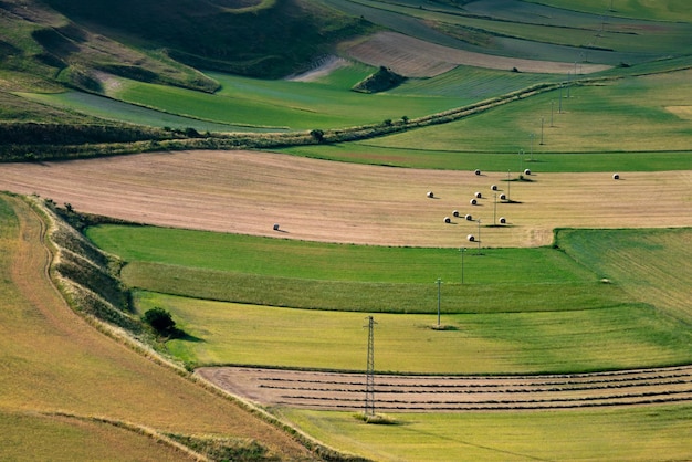 A field with a few bales of hay in the foreground