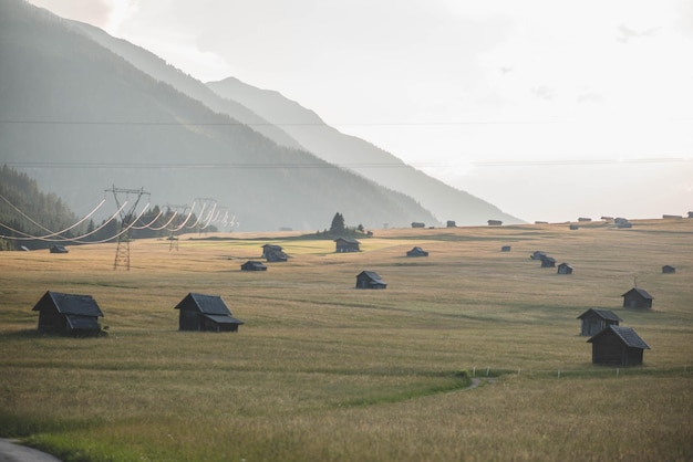 Foto un campo con una montagna sullo sfondo e una piccola capanna con una montagна sullo sfondo