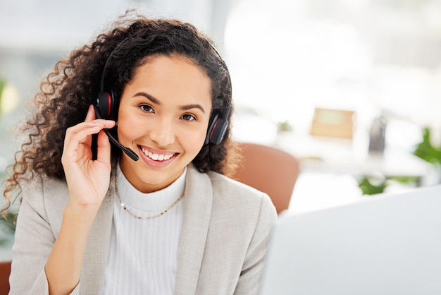 Photo fielding dozens of call with utmost professionalism portrait of a young businesswoman wearing a headset while working on a computer in an office