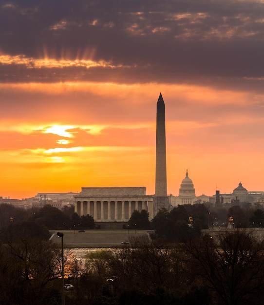 Photo fiery sunrise over monuments of washington