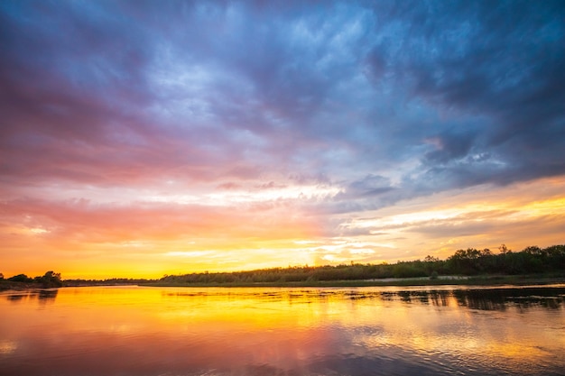 Foto tramonto ardente sul fiume con la riflessione in acqua