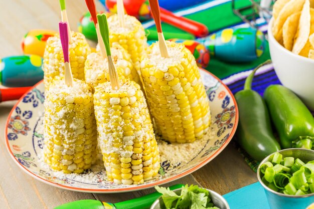 Fiesta feestbuffettafel met pittige Mexicaanse maïskolven en ander traditioneel Mexicaans eten.