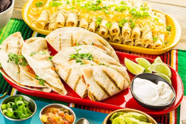 Fiesta party buffet table with chicken quesadilla and other traditional Mexican food.