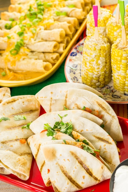 Fiesta party buffet table with chicken quesadilla and other traditional Mexican food.