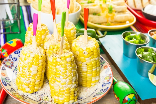 Fiesta party buffet table with spicy mexican corn on the cob and other traditional mexican food