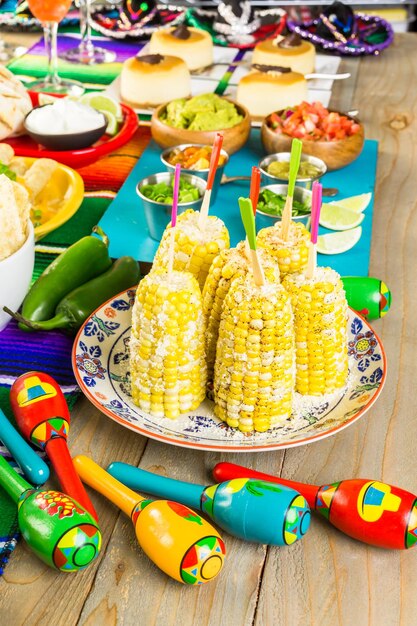 Fiesta party buffet table with spicy mexican corn on the cob
and other traditional mexican food.