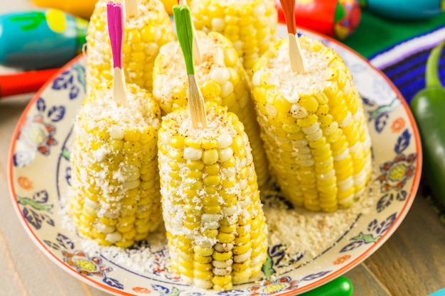 Fiesta party buffet table with spicy mexican corn on the cob\
and other traditional mexican food.