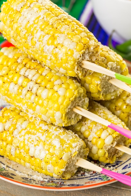 Fiesta party buffet table with spicy mexican corn on the cob and other traditional Mexican food.