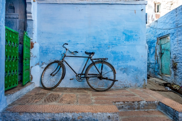 Fiets die op de blauwe muur leunt