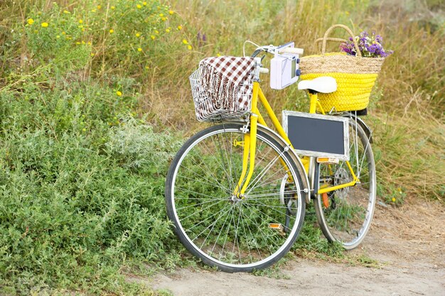 Foto fiets met krijtbord in de wei tijdens zonsondergang