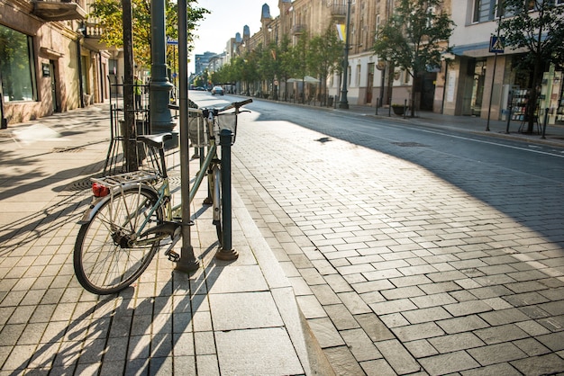 Fiets op stadsstraat met lege weg en ochtendlicht in Europa, Litouwen, Vilnius