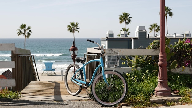 Fietscruiserfiets door oceaanstrand, de kust van Californië de V.S. Zomer fietsen, trappen en palmbomen.