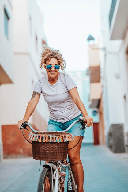 Fietsen aantrekkelijke en gelukkige vrouw op vakantie pedaal zorgeloos vrouw fietsen in de zomer milieuvriendelijk vervoer om de koolstofvoetafdruk van vrouwen die fietsen te verminderen